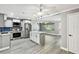 Bright kitchen features stainless appliances, kitchen island with a marble countertop, and grey cabinets at 528 Manor Dr, Dunedin, FL 34698