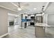 Bright kitchen features stainless appliances, grey cabinets and an island with marble countertop at 528 Manor Dr, Dunedin, FL 34698
