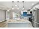 Beautiful kitchen featuring stainless steel appliances, granite counters, blue backsplash, and open sightlines to backyard at 528 Manor Dr, Dunedin, FL 34698