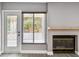 Cozy living room with fireplace, backyard view, and door leading to the outside at 528 Manor Dr, Dunedin, FL 34698