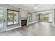 Spacious living room area features a fireplace, large windows, and light gray walls with light wood-look floors at 528 Manor Dr, Dunedin, FL 34698