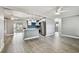 Open-concept living space with stylish gray walls, light wood flooring, and modern ceiling fans at 528 Manor Dr, Dunedin, FL 34698