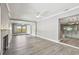 Spacious living room area features a fireplace, light gray walls, light wood-look floors, and open access to kitchen at 528 Manor Dr, Dunedin, FL 34698