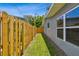 Narrow side yard with wooden fence and green grass at 528 Manor Dr, Dunedin, FL 34698