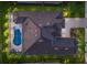 Aerial view of the home showcasing the roof, screened pool, hardscape, landscape and driveway at 5804 Mulligan Way, Lakewood Ranch, FL 34211