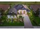 Aerial view of home showing roof, manicured lawn, tropical landscape, and paver driveway at 5804 Mulligan Way, Lakewood Ranch, FL 34211