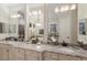Elegant bathroom with dual sinks, granite countertops, and modern lighting fixtures at 5804 Mulligan Way, Lakewood Ranch, FL 34211