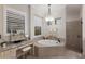 Luxurious bathroom featuring a soaking tub, a chandelier, a vanity, and windows at 5804 Mulligan Way, Lakewood Ranch, FL 34211