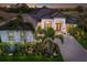 Stunning single-Gathering home showcasing lush tropical landscaping and a paver driveway at 5804 Mulligan Way, Lakewood Ranch, FL 34211