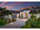 Charming single-Gathering home featuring a paver driveway, tropical landscaping, and stone accents at 5804 Mulligan Way, Lakewood Ranch, FL 34211