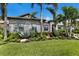 Home showcasing lush landscaping with stone details and palm trees at 5804 Mulligan Way, Lakewood Ranch, FL 34211