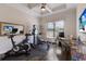 Home gym with exercise equipment, a ceiling fan, and a mounted television at 5804 Mulligan Way, Lakewood Ranch, FL 34211