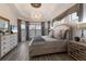 Serene main bedroom with hardwood floors, a chandelier, and ample natural light at 5804 Mulligan Way, Lakewood Ranch, FL 34211