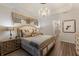 Spacious main bedroom showcases a chandelier, plank floors, neutral tones, and elegant furnishings at 5804 Mulligan Way, Lakewood Ranch, FL 34211