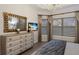 Bright main bedroom with a decorative mirror, television, and large windows with views at 5804 Mulligan Way, Lakewood Ranch, FL 34211