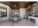 Outdoor kitchen with a built-in grill, stainless steel appliances, and a dining area at 5804 Mulligan Way, Lakewood Ranch, FL 34211