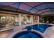 Gorgeous screened pool and patio area featuring a spa, lounge chairs, and an outdoor kitchen at 5804 Mulligan Way, Lakewood Ranch, FL 34211