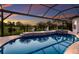 Sparkling screened in-ground pool with a spa overlooking a lush green lawn with mature palms at 5804 Mulligan Way, Lakewood Ranch, FL 34211