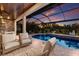 Screened-in pool area with comfortable seating and a view of the golf course at 5804 Mulligan Way, Lakewood Ranch, FL 34211