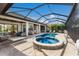 Beautiful screened-in pool with spa, outdoor seating, and access to the backyard living area at 5804 Mulligan Way, Lakewood Ranch, FL 34211