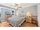 Cozy bedroom with wood floors, a ceiling fan, and a comfortable queen-sized bed with patterned bedding at 6002 34Th W Ave, Bradenton, FL 34209