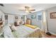 Bright bedroom with wood floors, ceiling fan, and a comfortable queen-sized bed with green patterned bedding at 6002 34Th W Ave, Bradenton, FL 34209