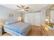 Bedroom featuring wood floors, closet, dresser, and a comfortable queen-sized bed with blue bedding at 6002 34Th W Ave, Bradenton, FL 34209