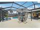 A screened-in patio with an umbrella table and loungers next to a sparkling pool at 6002 34Th W Ave, Bradenton, FL 34209