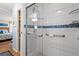 Modern bathroom features a glass enclosed shower, grab bars, and attractive blue tile accent at 617 Fairmount Dr, North Port, FL 34287