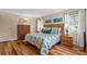 Comfortable bedroom featuring wood floors, a rattan headboard, and beach-themed decor at 617 Fairmount Dr, North Port, FL 34287