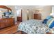 Bright bedroom features wood floors, a beach-themed bedspread, and an ensuite bathroom at 617 Fairmount Dr, North Port, FL 34287