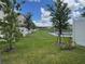 A beautiful backyard featuring a lush lawn and a scenic view of the lake beyond the white fence at 6253 Whetstone Ct, Palmetto, FL 34221