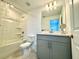 Bright bathroom with a shower-tub combo, gray vanity, and modern fixtures at 6253 Whetstone Ct, Palmetto, FL 34221