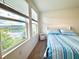 A serene bedroom with ample natural light and a beautiful lake view at 6253 Whetstone Ct, Palmetto, FL 34221