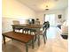 Open-concept dining area with tile flooring, a wooden table, and a bench near sliding glass doors to the backyard at 6253 Whetstone Ct, Palmetto, FL 34221