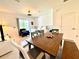Dining area with wooden table and a view into the living room and through the sliding glass doors to the backyard at 6253 Whetstone Ct, Palmetto, FL 34221