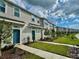 Townhome exterior showcasing landscaped front yard and inviting blue front doors at 6253 Whetstone Ct, Palmetto, FL 34221