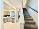 Bright hallway featuring easy access to both the kitchen and the carpeted staircase at 6253 Whetstone Ct, Palmetto, FL 34221