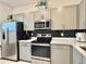 Modern kitchen features stainless steel appliances and a sleek, black backsplash at 6253 Whetstone Ct, Palmetto, FL 34221