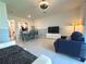 Bright, open-concept living room and dining area with a tv, comfortable seating, and light-colored tile flooring at 6253 Whetstone Ct, Palmetto, FL 34221
