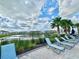 Community pool area with lounge chairs, palm trees, and picturesque water views at 6253 Whetstone Ct, Palmetto, FL 34221