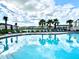 A refreshing community pool beckons with lounge chairs, landscaped areas and stunning clouds reflecting in the water at 6253 Whetstone Ct, Palmetto, FL 34221