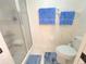 Bathroom featuring a shower and toilet, accessorized with blue towels and floor mat at 6507 Stone River Rd # 302, Bradenton, FL 34203