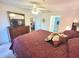 Bedroom features a ceiling fan, a dresser with TV, and a view leading to a bathroom and sitting room at 6507 Stone River Rd # 302, Bradenton, FL 34203