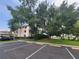 Condo complex featuring covered parking, mature trees, and colorful awnings at 6507 Stone River Rd # 302, Bradenton, FL 34203