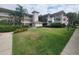 Well-maintained condo building surrounded by a manicured lawn with mature trees and tropical vegetation at 6507 Stone River Rd # 302, Bradenton, FL 34203