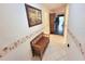 Bright condo hallway with tiled floor, wall decor, and a wooden bench at 6507 Stone River Rd # 302, Bradenton, FL 34203