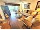 Cozy living room with plush sofas, a ceiling fan, balcony access, and a decorative fireplace with a guitar at 6507 Stone River Rd # 302, Bradenton, FL 34203