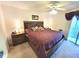 Spacious main bedroom with a ceiling fan, balcony access, and a comfortable bed with decorative pillows at 6507 Stone River Rd # 302, Bradenton, FL 34203