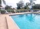 The community pool features lounge chairs, a safety ring, and mature landscaping at 6507 Stone River Rd # 302, Bradenton, FL 34203